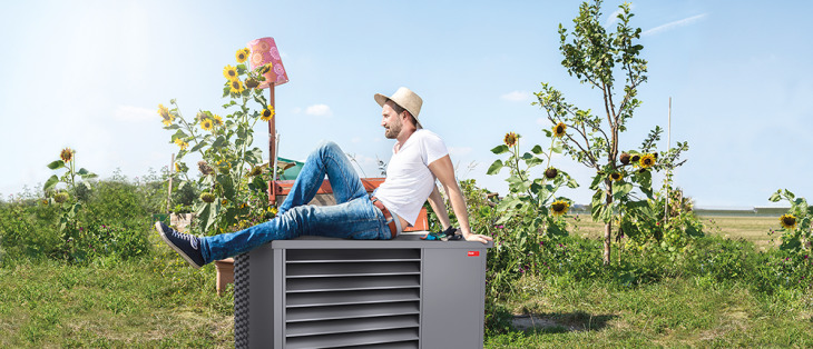 Un homme assis sur une pompe à chaleur monobloc